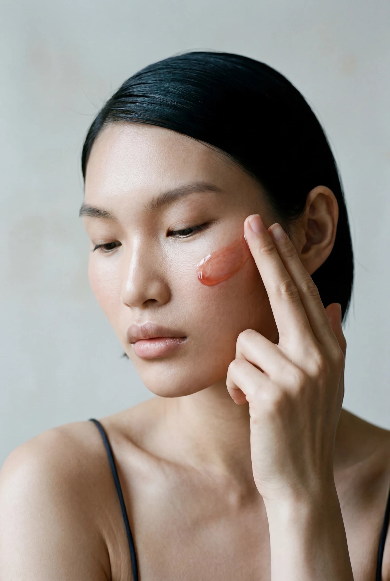 Application — serum swept across the cheek with the fourth finger.